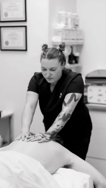 Black-and-white photo of Rachel giving a back massage at NakedCat Beauty